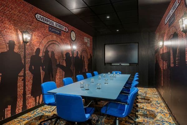 Liverpool St Meeting Room with blue table and chairs and silhoulette walls